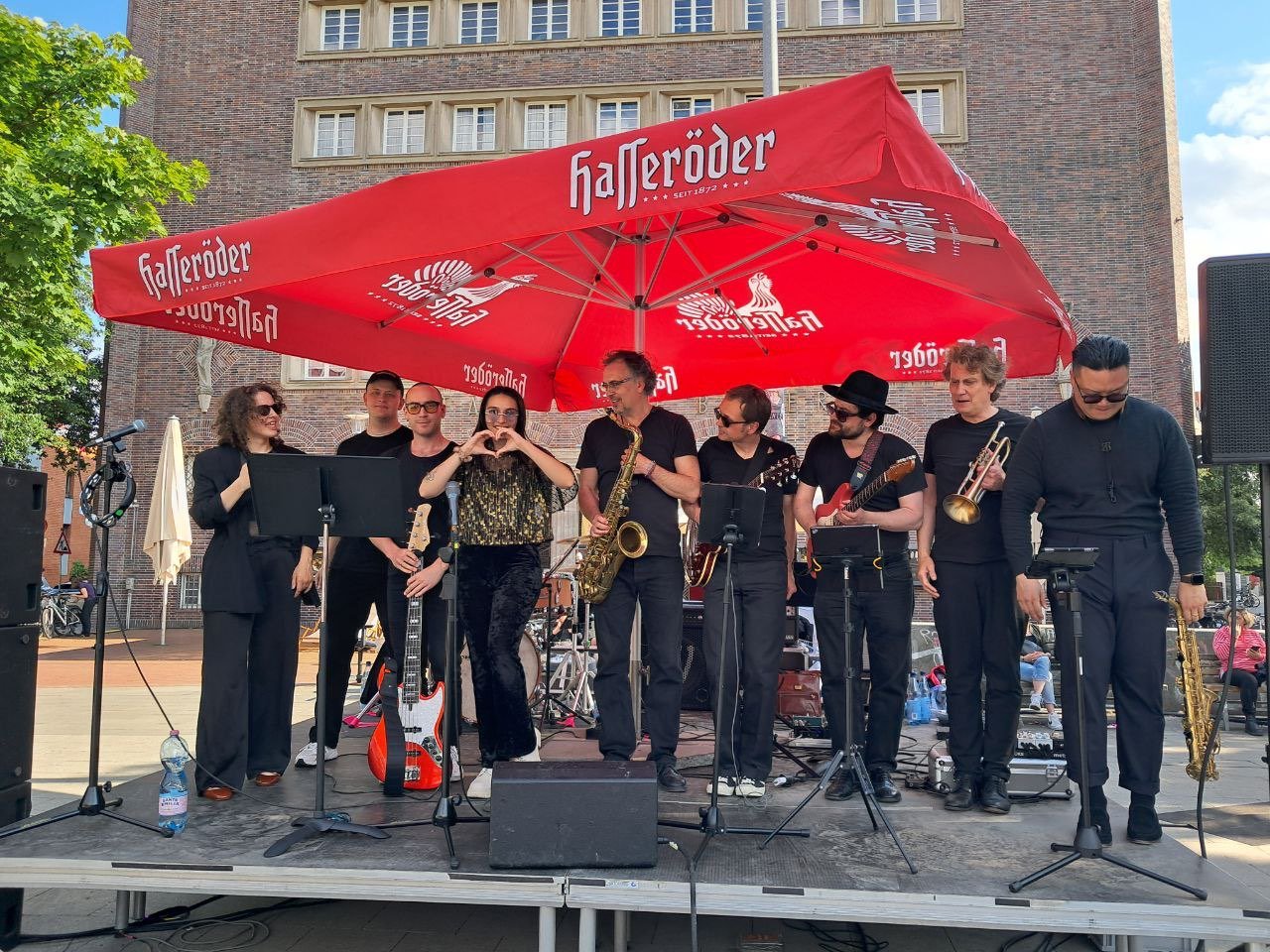 Die neunköpfige Guilty Pleasure Power Band mit Bläsersatz auf einer Open-Air-Bühne
